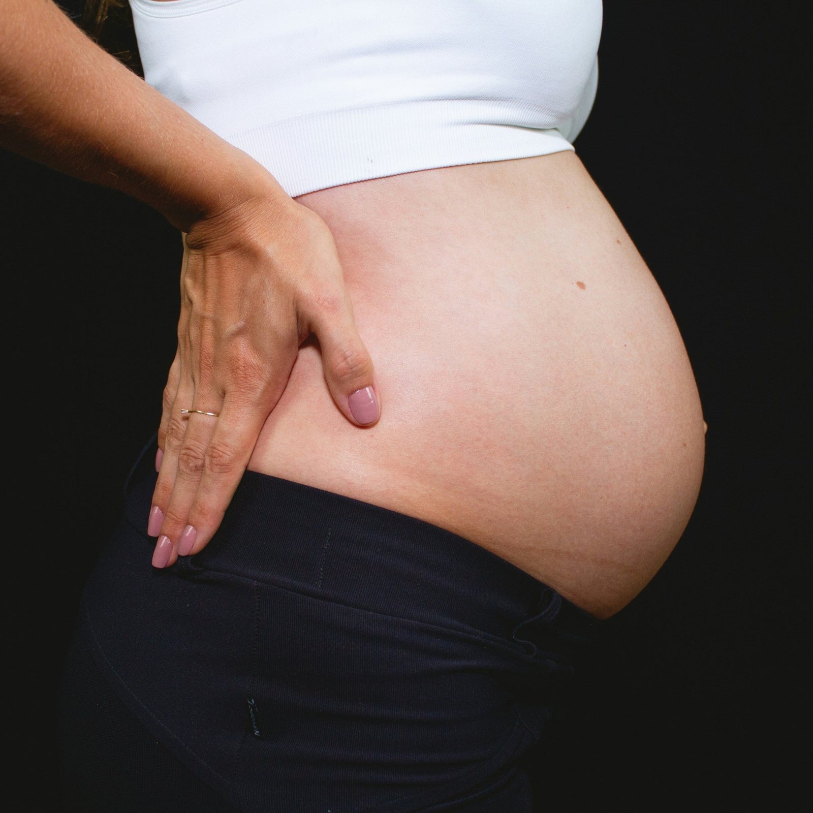 Pregnant woman gently touching her belly