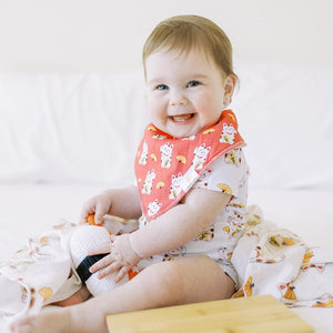 cute baby in lucky cat red bib sitting smiling