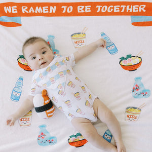 cute baby laying on the wee bean milestone blanket in ramen noodle