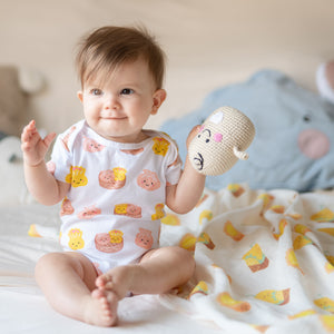 cute baby playing with doll in the wee bean super soft organic cotton baby onesie bodysuit romper in dim sum from taste of hong kong collection