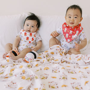 cute little babies in the wee bean organic cotton and bamboo muslin swaddle lucky cat