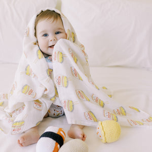 baby playing with the wee bean organic cotton and bamboo swaddle in cup noodle