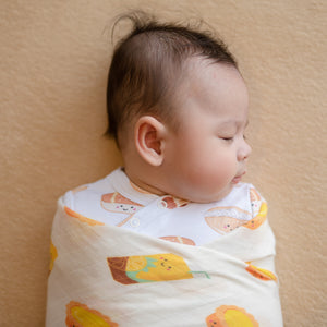 cute baby swaddled and sleeping in the wee bean organic cotton and bamboo swaddle in vita lemon tea and egg tart