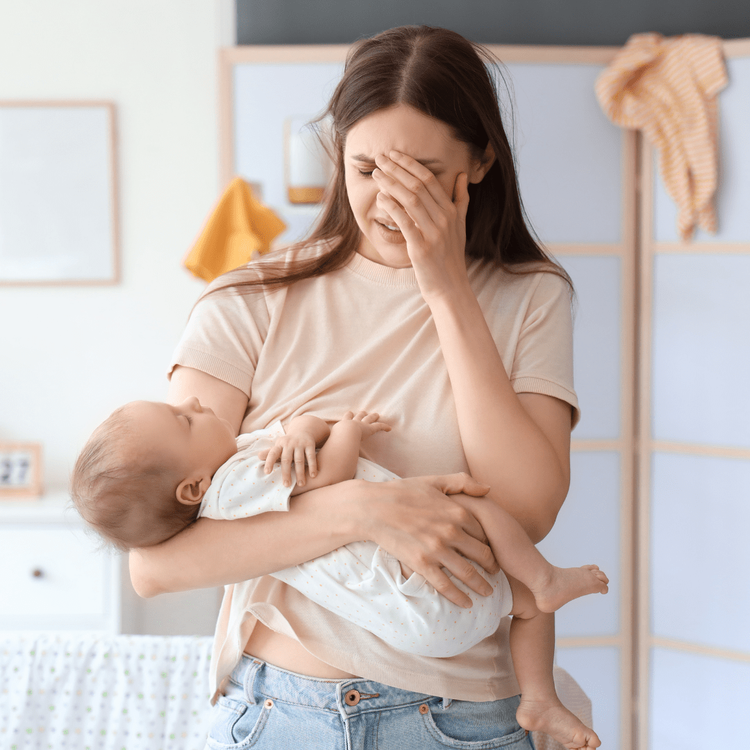 An anxious woman holding her baby