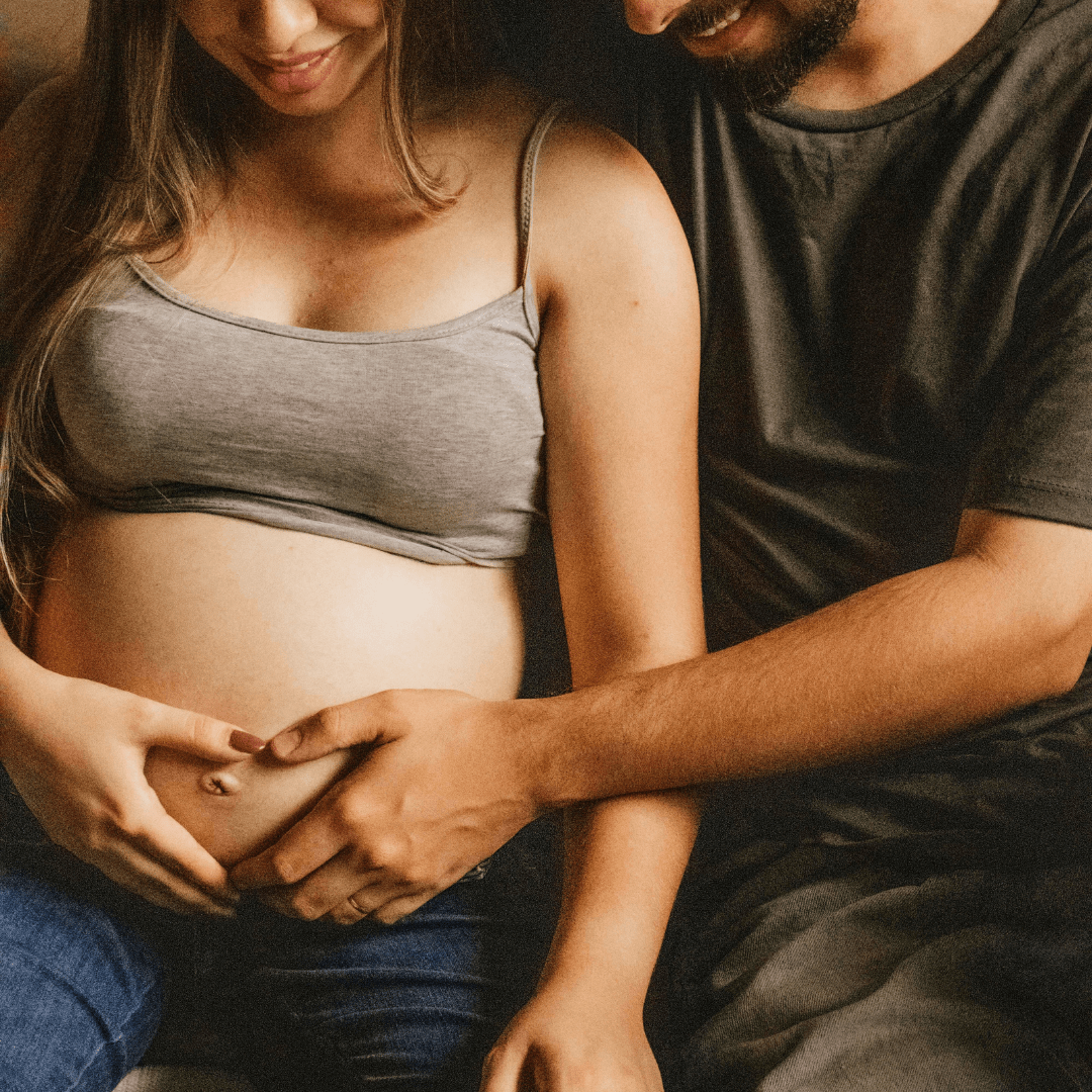 Husband and wife touching baby belly