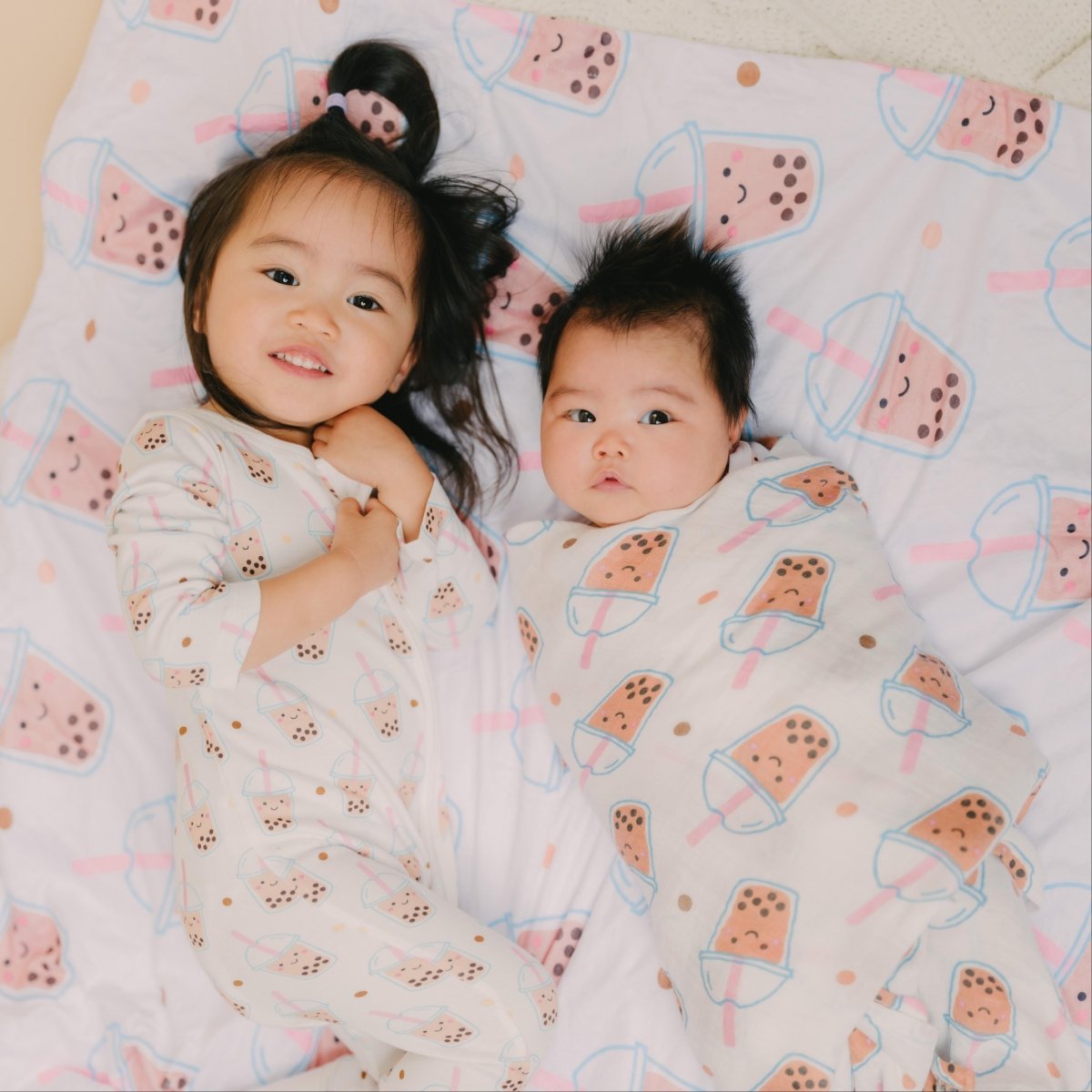 two sisters in the wee bean's boba collection boba romper, swaddle and minky blanket