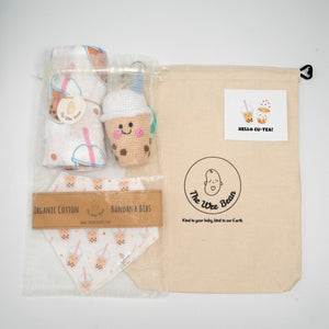 Baby product set with organic cotton bandana bibs, plush toy, and blanket in a branded bag.
