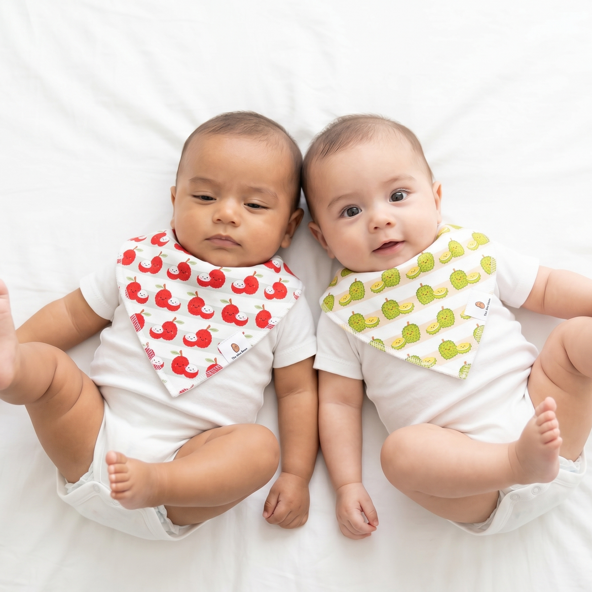 Two babies wearing The Wee Bean's Fruit Bibs