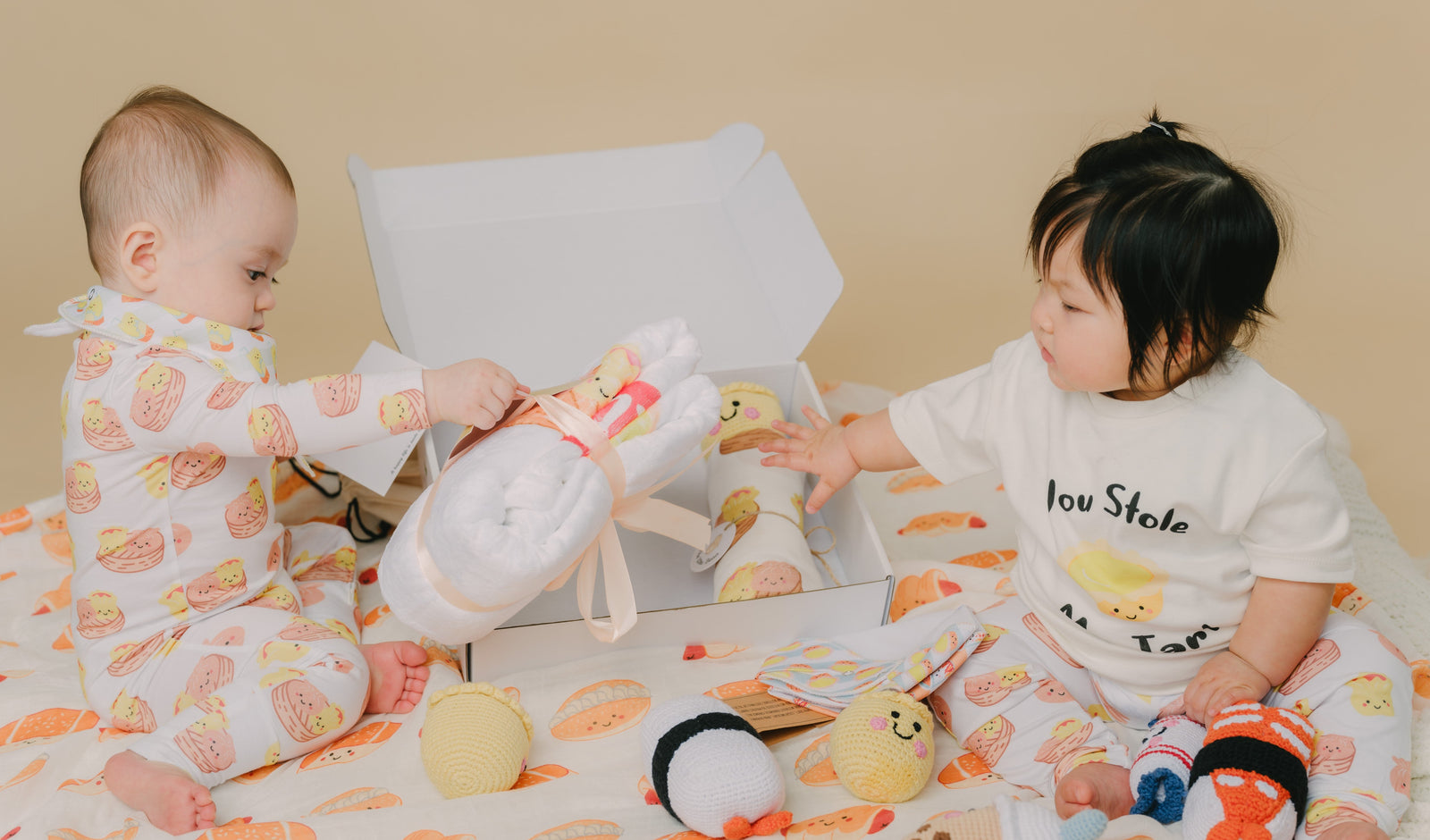 Two children playing with toys on a dim sum blanket.