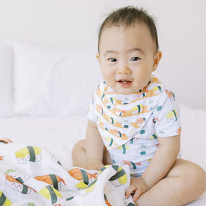 cute baby wearing the wee bean organic cotton bib set in sushi