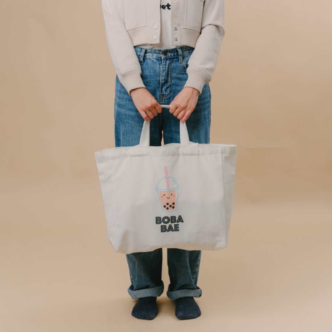 The  Wee Bean eco-friendly canvas reusable tote bag in Boba Bae with dolls and swaddle matching