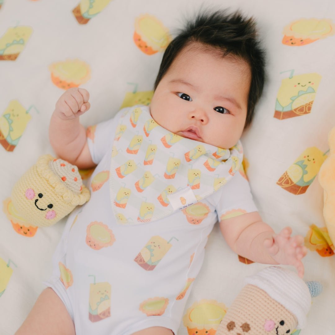 cute baby laying down in the wee bean lemon tea and egg tart onesie and swaddle