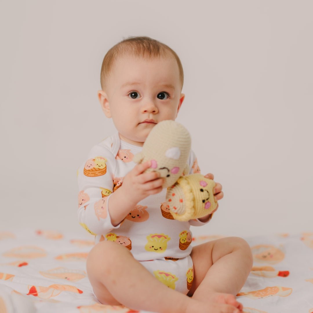 Baby holding a plush toy with a plain background