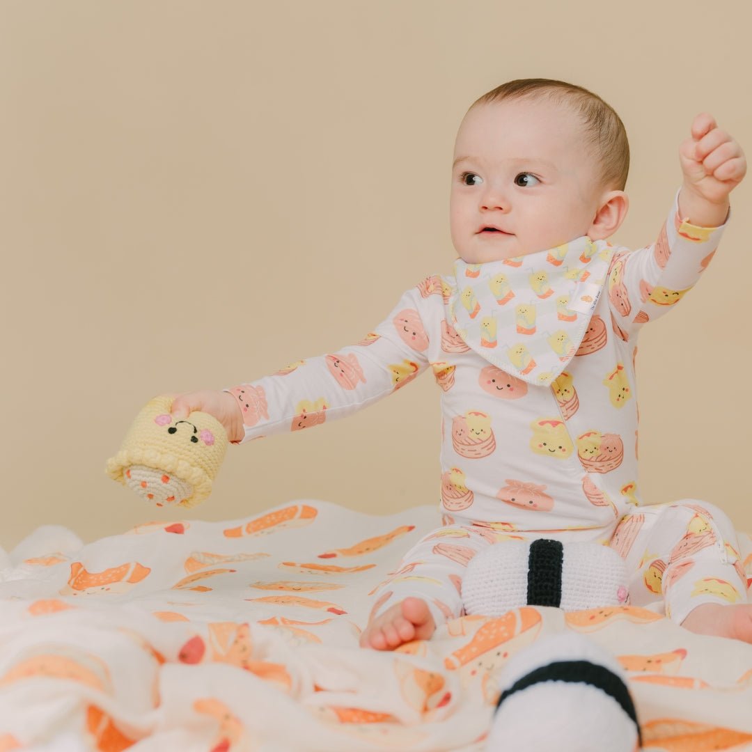 cute baby in lemon tea bib holding siu mai doll