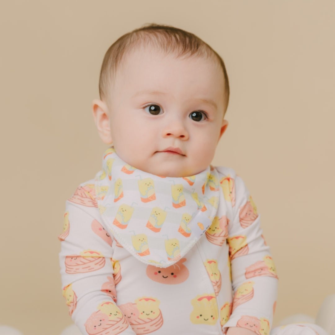 Baby wearing a onesie with lemon tea print bandana bib