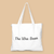 White tote bag with a colorful graphic of a cityscape and cartoon characters on a beige background