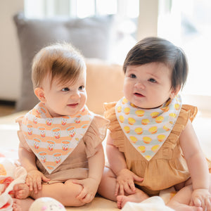 two cute babies wearing the wee bean organic cotton bandana bibs in milk tea and egg tart
