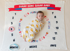 swaddled baby laying on the wee bean yakult white rabbit candy mr softee ice cream baby milestone blanket growth tracker newborn photography