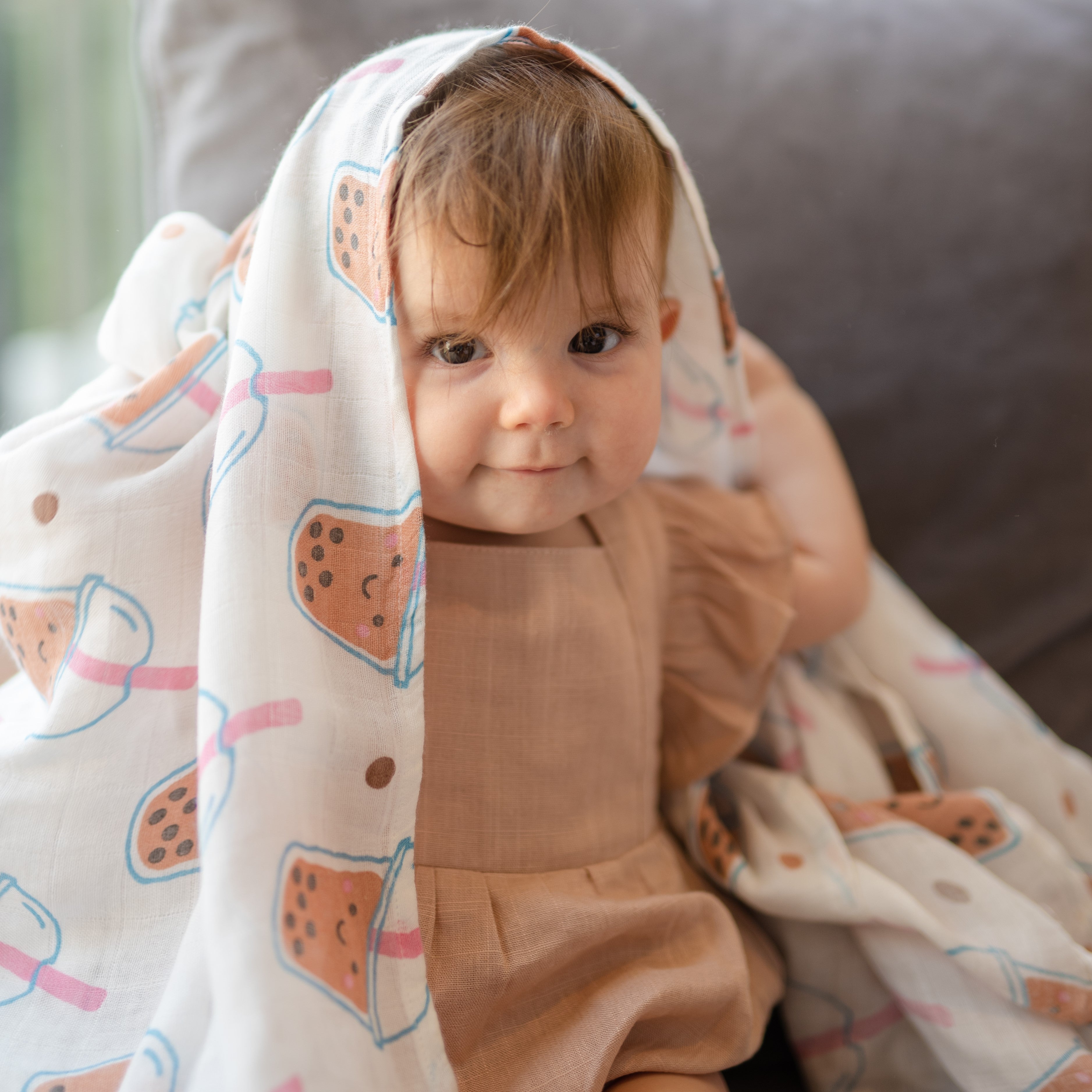 cute baby playing peekaboo in the wee bean super soft organic cotton and bamboo swaddle in boba bubble tea