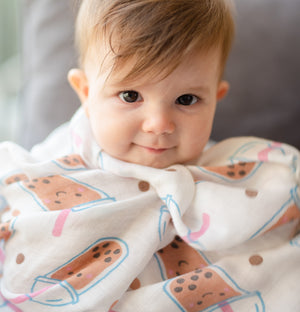 cute baby snuggling up in the wee bean super soft organic cotton and bamboo swaddle in boba bubble tea
