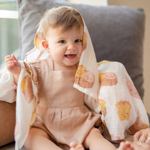 baby smiling in the wee bean organic cotton swaddle in dim sum