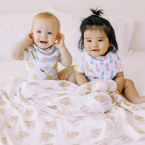 two babies in the wee bean organic cotton and bamboo swaddle in cup noodle and bibs in cup noodle and ramune soda