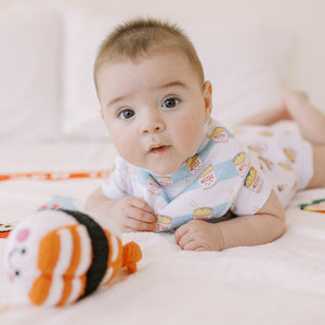 cute baby doing tummy time in the wee bean organic cotton bib in cup noodle