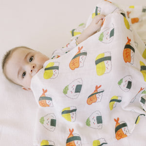 the wee bean cute baby snuggled in the wee bean organic bamboo swaddle in sushi