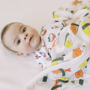 cute newborn baby with the wee bean organic cotton swaddle in sushi