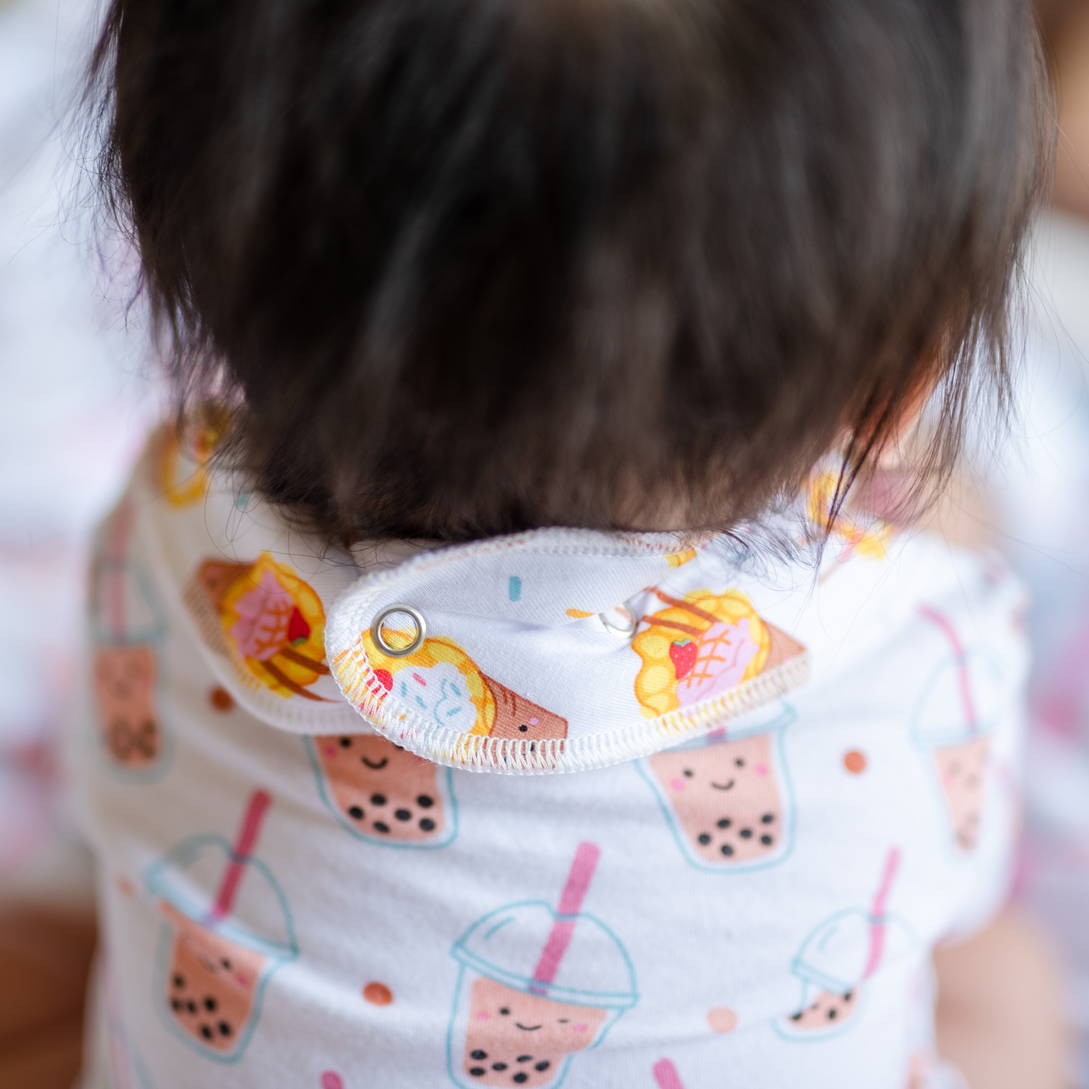 cute baby wearing the wee bean organic cotton bib in egg waffle sundae adjustable snap button