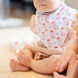 baby wearing the wee bean organic cotton bib set in yakult